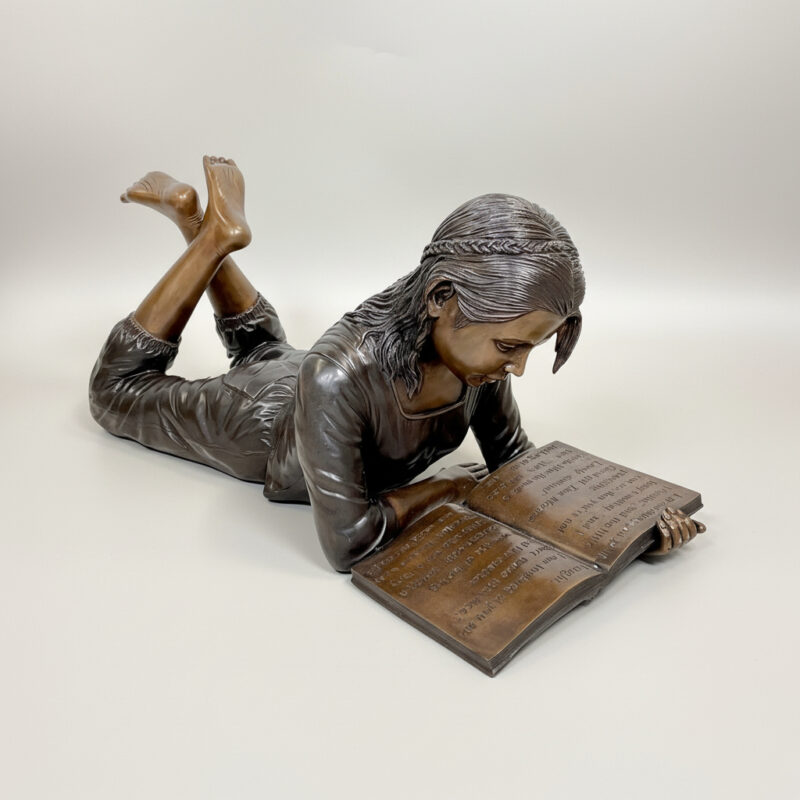 SRB48408 Bronze Lying Girl Reading Book Sculpture by Metropolitan Galleries Inc.