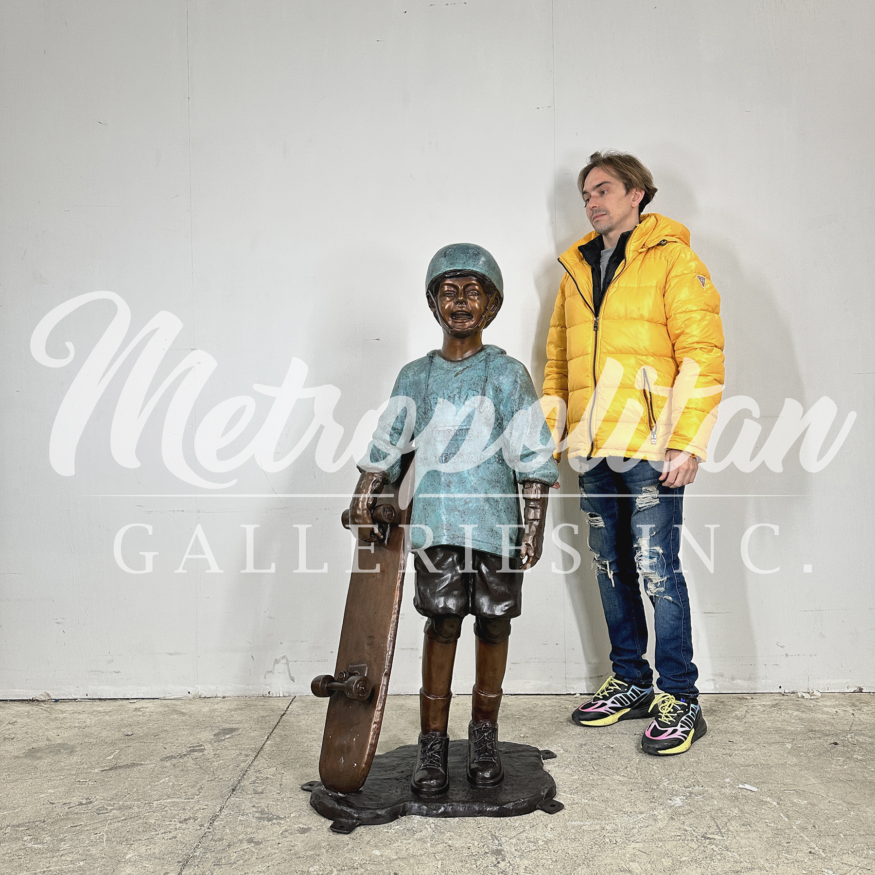 SRB074010 Bronze Boy holding Skateboard Sculpture by Metropolitan Galleries Inc SCALE WM